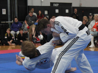 Kickboxing Thumbnail An adult student is performing a takedown technique on another student in class