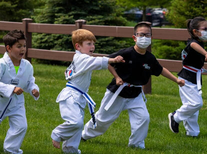 Four little tiger students are demonstrating hand techniques as a group