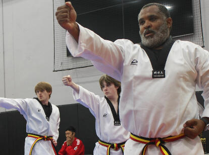 Three adult and teenage students are each demonstrating a close-handed strike
